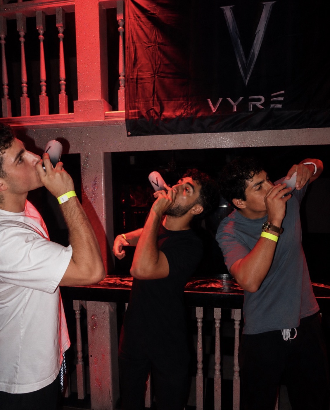 Friends drinking VYRE under the VYRE banner
