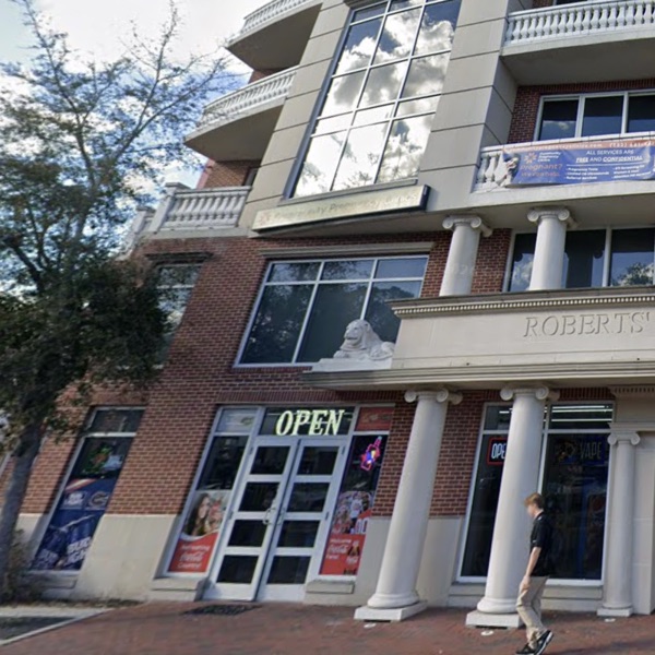 Quick Mart storefront on W University Ave, ground floor of Roberts' Stadium Club